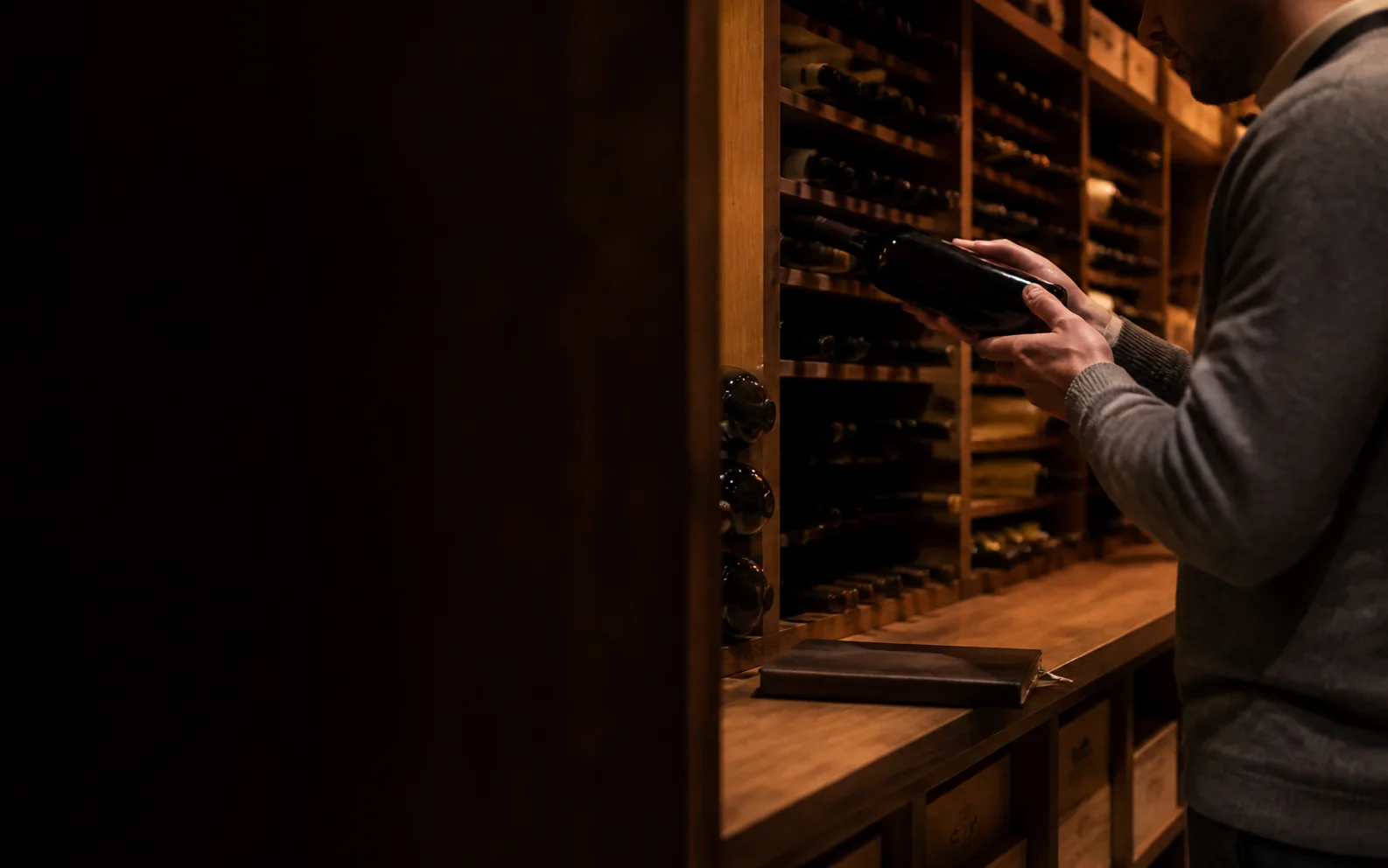 An unbranded fine-wine collection being reviewed in a private cellar